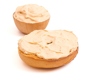 A Pumpkin Bagel with Pumpkin Cream Cheese Spread Isolated on a White Background