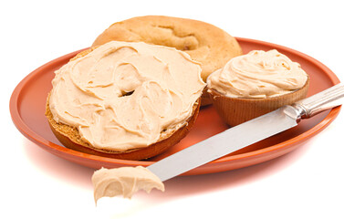 A Pumpkin Bagel with Pumpkin Cream Cheese Spread Isolated on a White Background