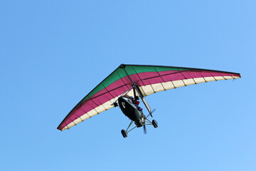 Ultralight airplane flying in a blue sky	