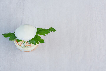 Salad and parsley leaves filled into egg shell on an egg holder on marble background