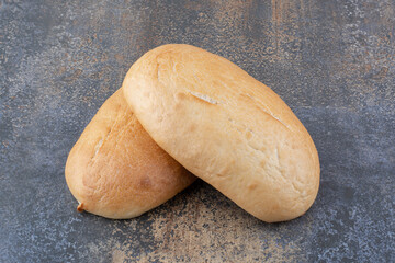 Two oval buns displayed on marble background