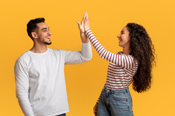 Portrait Of Happy Young Arab Couple Giving High Five To Each Other