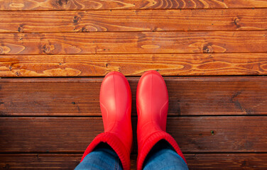 woman in red boots on the porch of the house before a walk in autumn