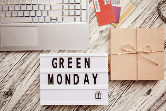 Lightbox with Green Monday text, craft gift box, payment cards and laptop. Concept of online shopping. High quality photo