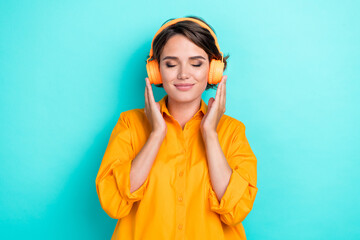 Photo of young pretty attractive cute nice woman girlish closed eyes dreamy listen headphones music comfort isolated on aquamarine color background