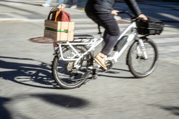 Konzeptfoto für alternative Transportmöglichkeit: Frau fährt auf einem Lastenrad - Pedelec