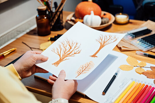 Autumn painting ideas, easy fall painting for adults, for beginners. Autumn Scenes. Faceless portrait of woman drawing autumn trees with markers.