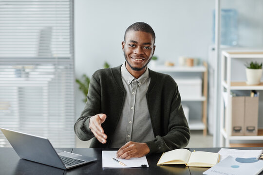 Front View Portrait Of Young Black Man Smiling At Camera In Job Interview And Holding Hand For Greeting