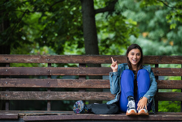 Young woman pointing fingers at an empty space next to her