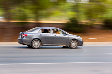 Panning shot of a car driving on a highway. Blurred photo
