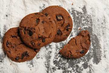 fresh chocolate cookies with chocolate chips on wooden desk