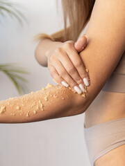 Woman applies scrub. Sugar scrub for body, face. Home care. Natural