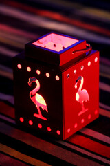 Ein Windlicht mit einem Teelicht zur Beleuchtung steht auf dem Tisch.