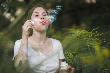 happy alternative & spiritual looking hipster girls makes soap bubbles & blows them in the air...