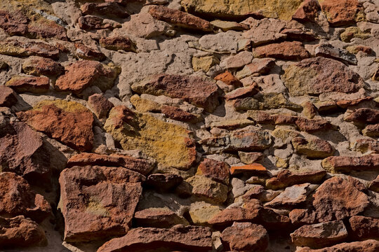 Stara ściana z kolorowych piaskowców scalonych wapienną zaprawą .