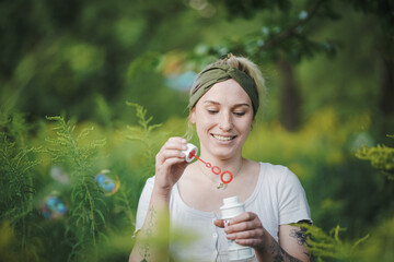 happy alternative & spiritual looking hipster girls makes soap bubbles & blows them in the air...