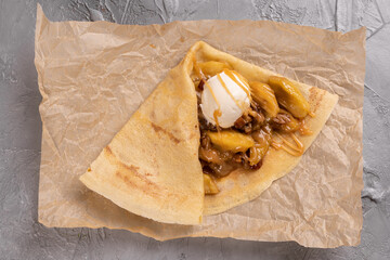 Crepes stuffed with fruit and nuts. Served with ice cream ball. Thin pancakes, sweet dessert