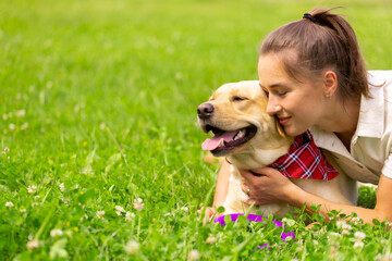 Young woman with her cute yellow labrador outside. Lovely pet, animal love concept