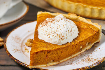 Piece of pumpkin pie with whipped cream