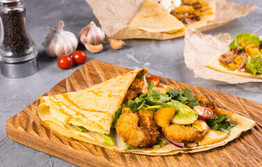 Pancake or crepe with fried shrimp tomatoes and vegetables and cheese
