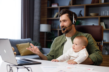 Father on maternity leave, holding an online conference, a meeting in the home office with a small child in his arms. Dad with a child. Freelancer combines child care and work. Paternity leave