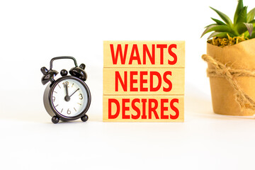 Wants needs and desires symbol. Concept words Wants Needs Desires on wooden blocks. Black alarm clock. Beautiful white background. Business, psychological wants needs and desires concept. Copy space.