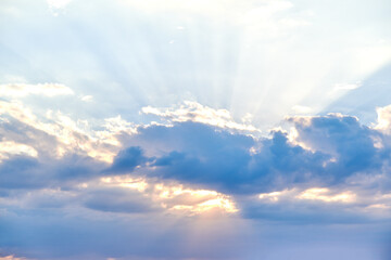 Rays of the sun shine in the sky through the dramatic blue clouds  - Powered by Adobe