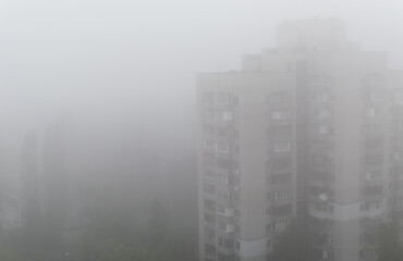 Blurred image of multi-storey residential building in dense fog