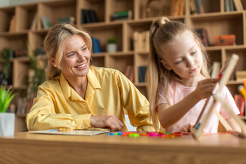 Child development classes concept. Friendly professional female teacher exercising with preschool girl