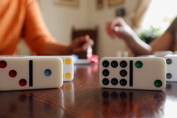 Domino or Mexican train game. Board game with tiles. Person in the background. Close up and isolated.