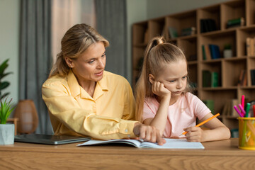 Strict mother studying with little schoolgirl daughter, scolding lecture for bad marks, girl...