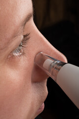woman with vacuum face pore cleaner, skin care