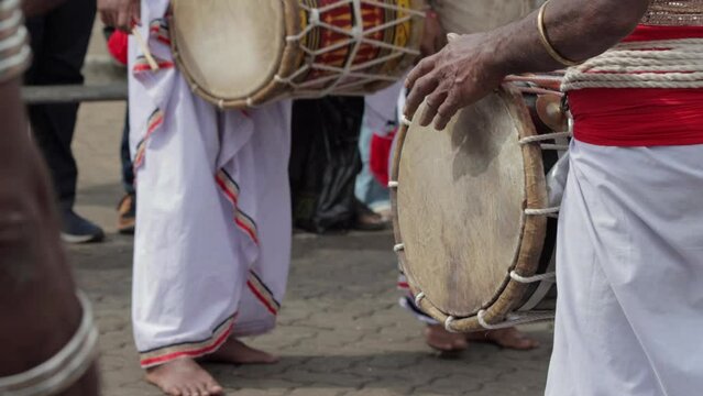 Dark-skinned Asian Drummer makes Drumming Tunes on Beraya which is a typical drum instrument from Sri Lanka
