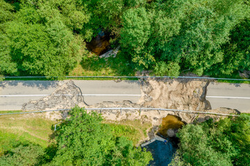 The asphalt road and bridge washed out and destroyed after the heavy rain and flood. Aerial photo