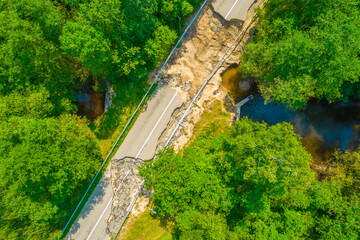 The asphalt road and bridge washed out and destroyed after the heavy rain and flood. Aerial photo