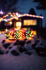 out of focus holiday lights at house in snow