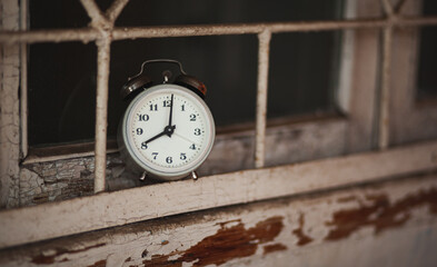 Old alarm clock on the windowsill