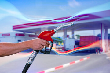 A man fills up a car at a gas station on technological background. Graph of rising prices for gasoline and fuel.