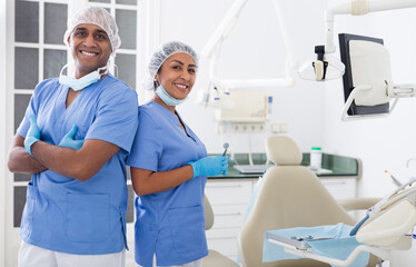 Portrait of positive dentist with assistant at workplace in clinic