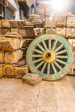 Wooden cart wheel and floor tiles in an alley in Cairo.