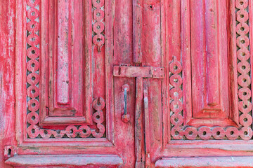 Decorative woodwork on a weathered antique door.