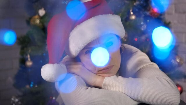 Lonely female celebration in Christmas room. A lonely woman pas her time in the room with Christmas atmosphere.