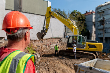 Site manager   standing at the construction site of a private property, supervising, inspecting or...