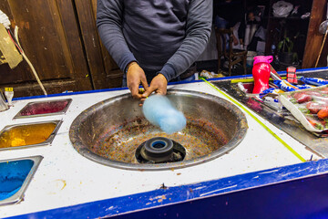 Man making spun sugar, cotton candy, at a shop on El Moez street in Old Cairo.