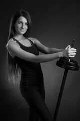 young strong woman raises the barbell