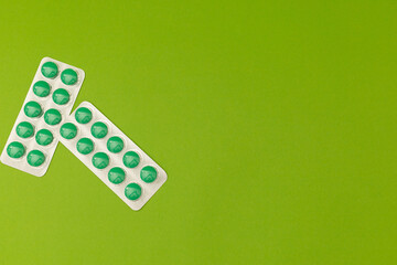 Green pills on a green background, monochrome