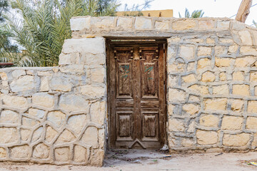 Fototapeta na wymiar Wooden door in a wall in the village of Faiyum.