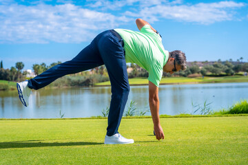 Male golf player on professional golf course. Golfer with driver stick by a lake