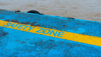 Yellow line safety zone on floor at waterside,Old rusted metal background, iron pier with safety...