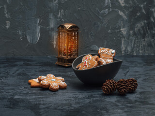 Christmas card with glazed gingerbread, fir cones and a glowing lantern